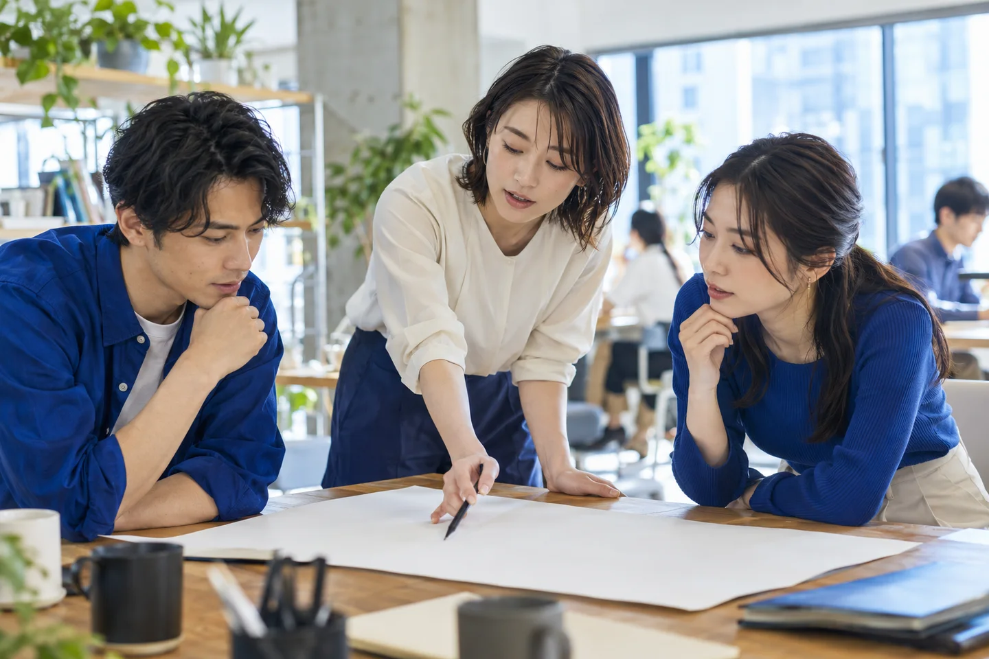 明るいオフィスで、互いの意見を交わす若い社会人たち